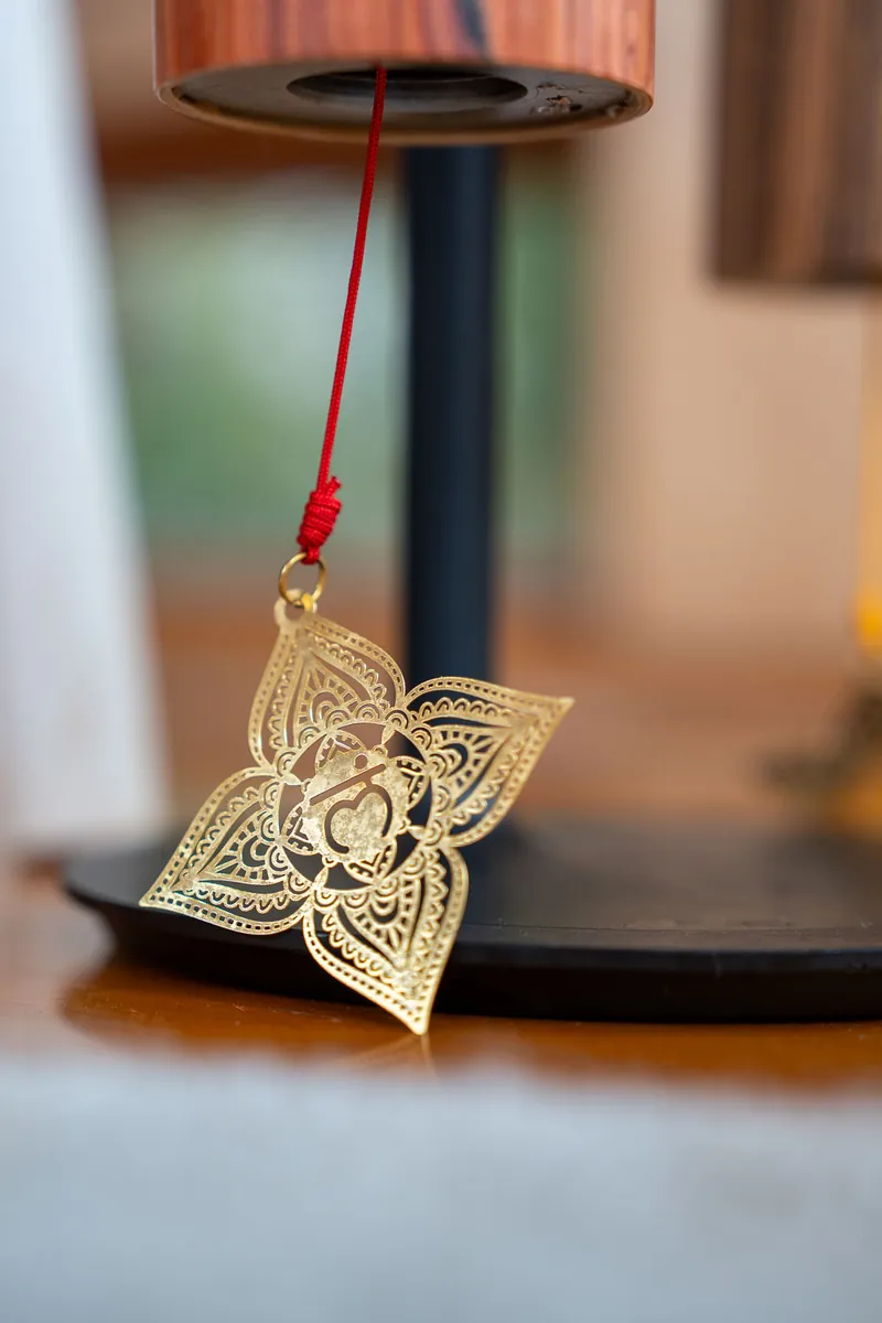 A golden chime hanging in soft light