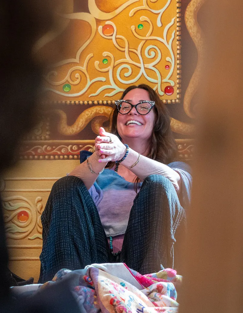 A woman laughing freely, wrapped in a blanket
