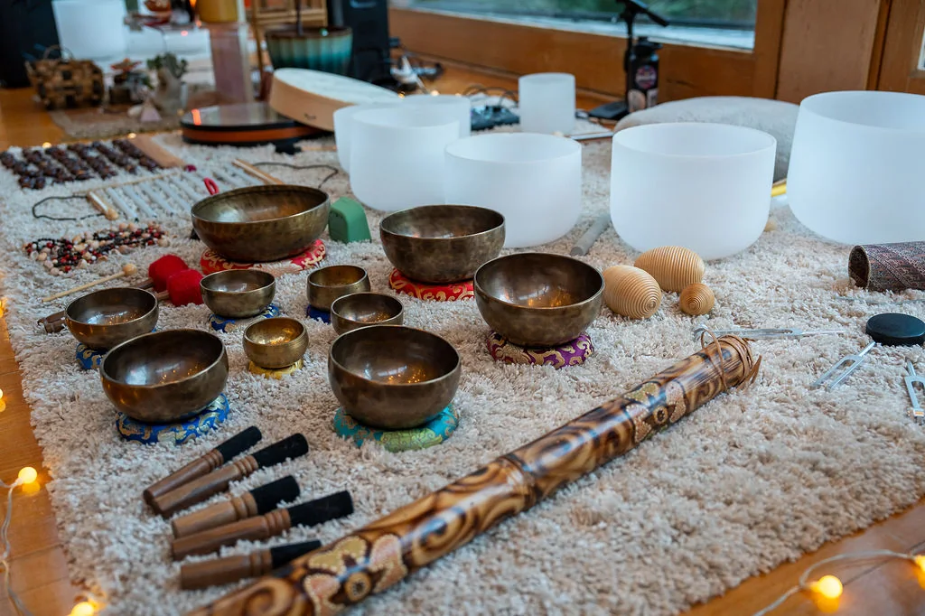 Singing bowls and crystal bowls arranged for a sound bath
