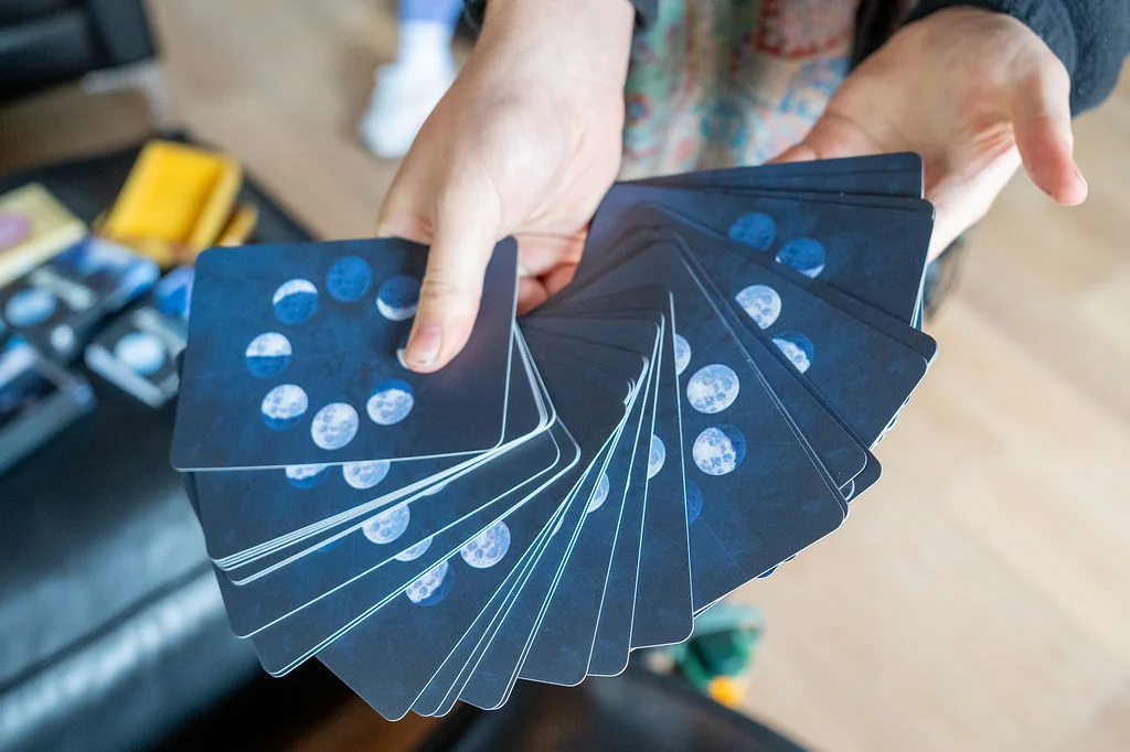 Hands fanning a deck of moon oracle cards