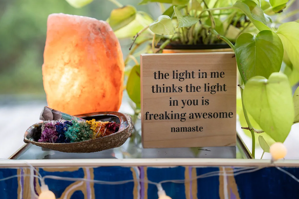 A glowing salt lamp beside a sign that reads the light in me thinks the light in you is freaking awesome