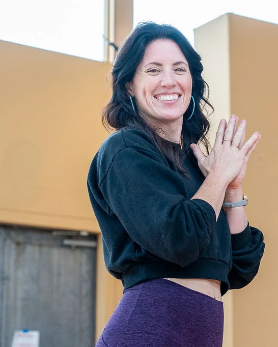 Sarah smiling warmly with her hands together at last year’s retreat
