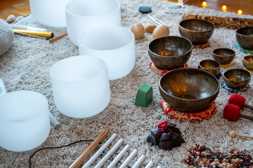 A sound bath set up on a soft rug with candles