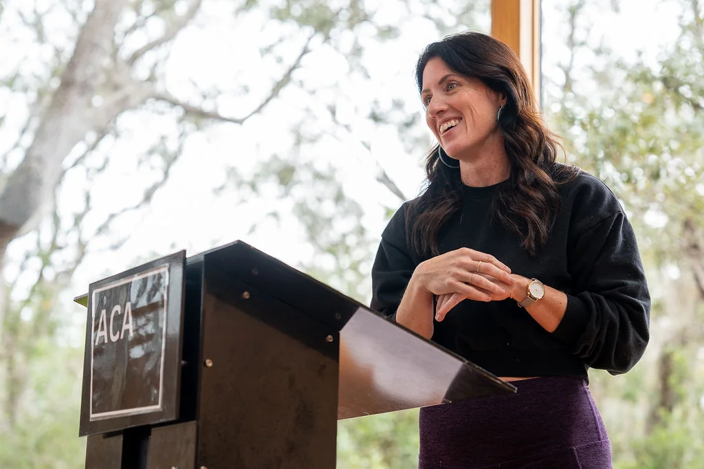 Sarah laughing as she speaks from the podium