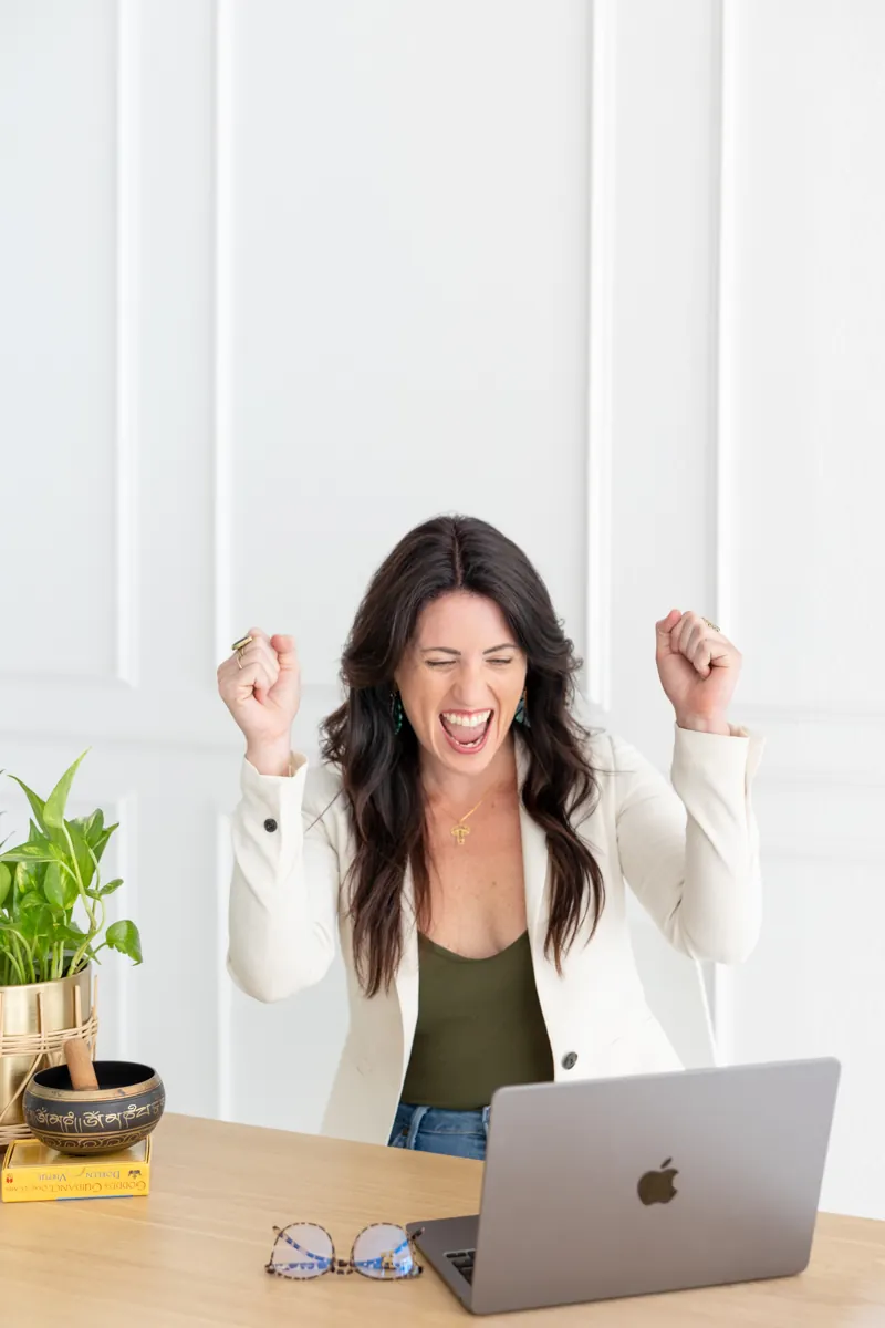 Sarah celebrating at her laptop