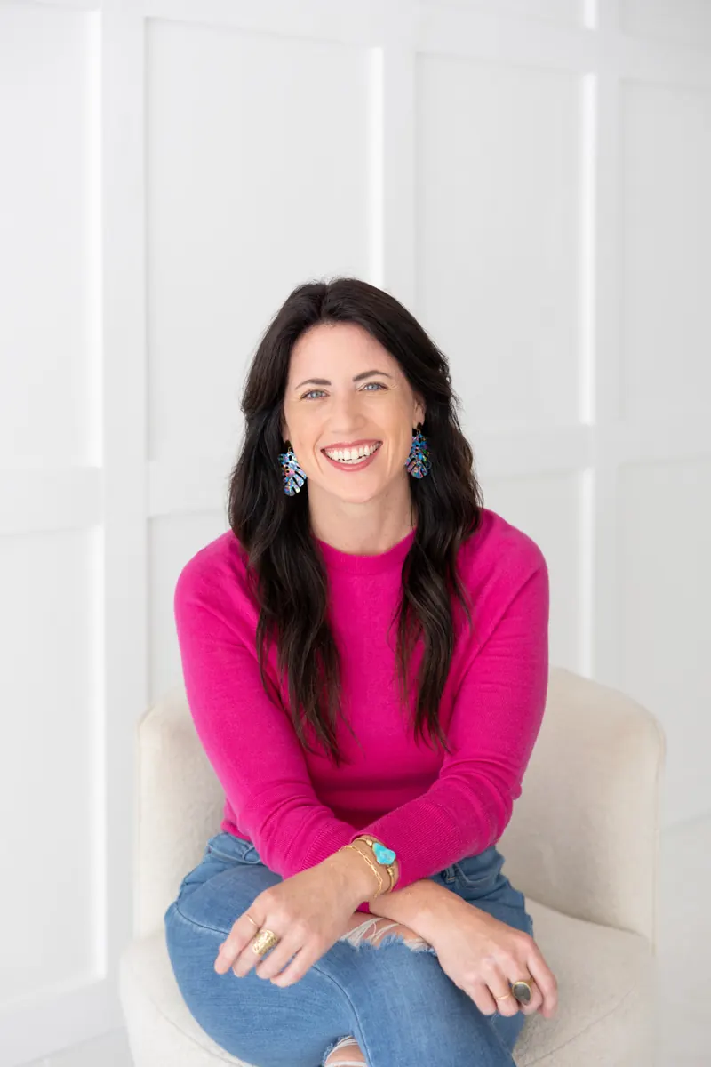 Sarah Burnett smiling, seated in a white chair