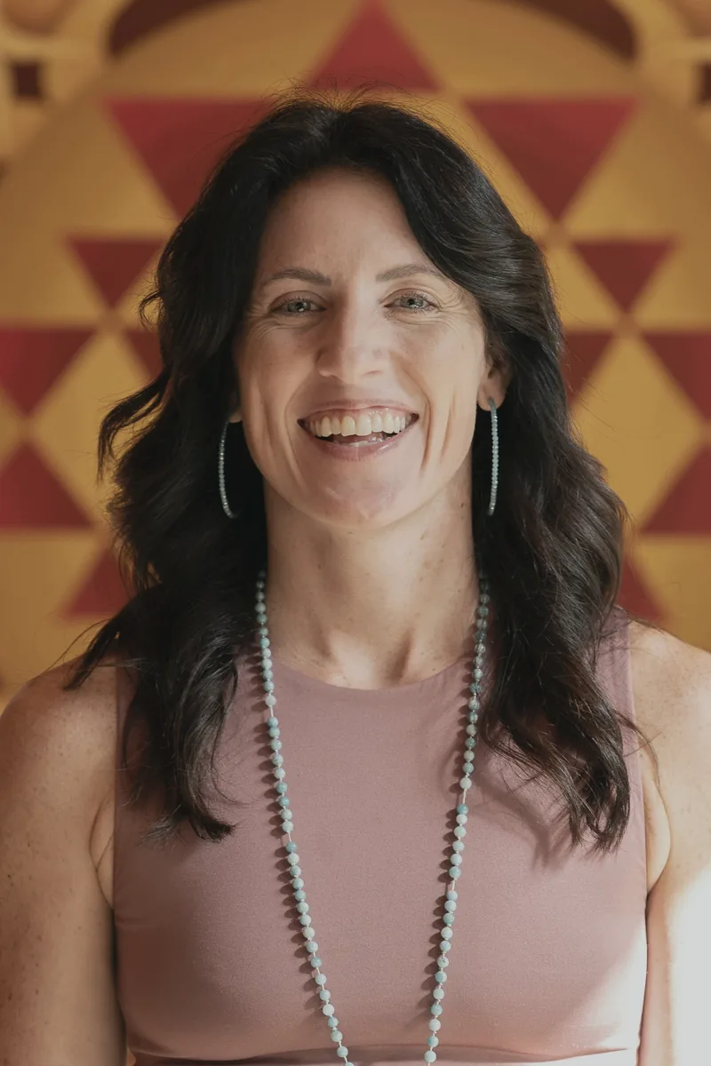 Sarah Burnett, LMHC, smiling warmly in her healing space